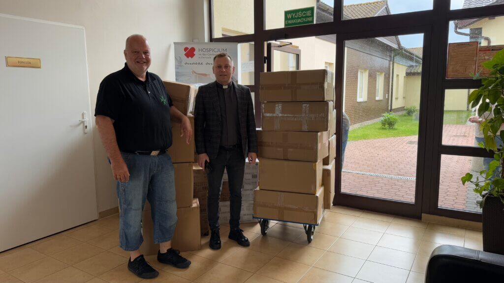 Das Bild zeigt Dirk Augustin vom Sankt Lazarus Orden und Hospiz-Direktor ks. Krzysztof Sendecki vor den Spendengütern. 
